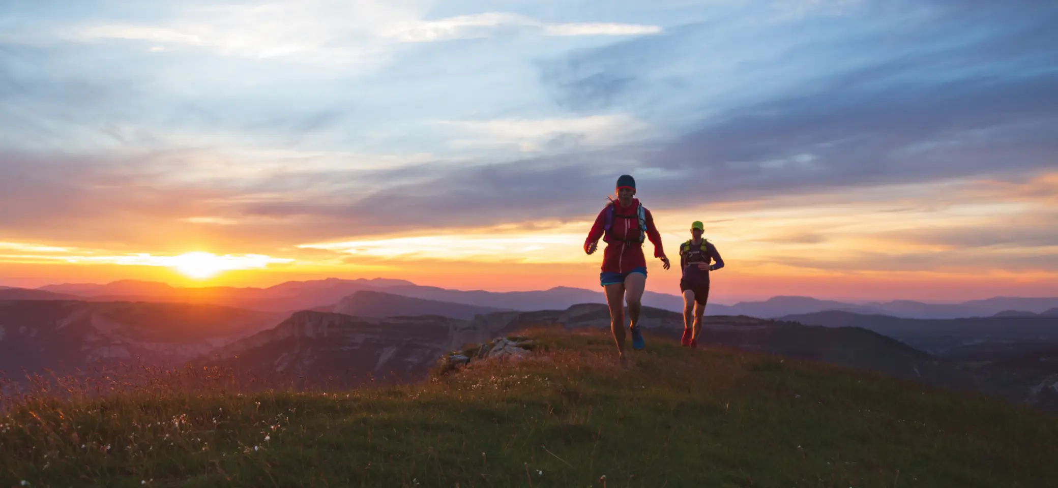 Zwei Läufer in der Abendsonne am Berg | © canva