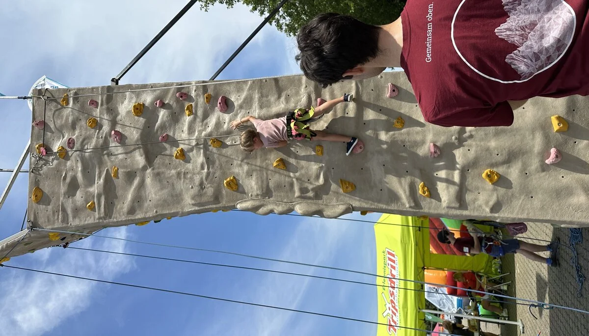 Junger Mann sichert kletterndes Kind | © Sandra Holte