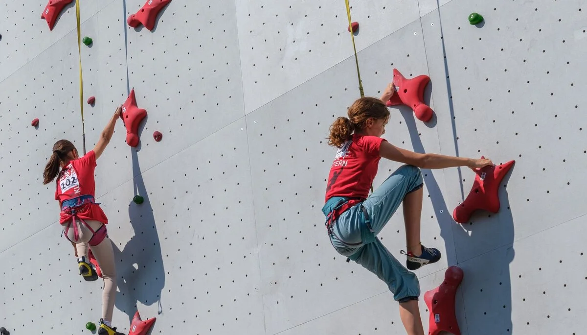 Zwei kletternde Mädchen an einer Kletterwand | © Oliver Gobin