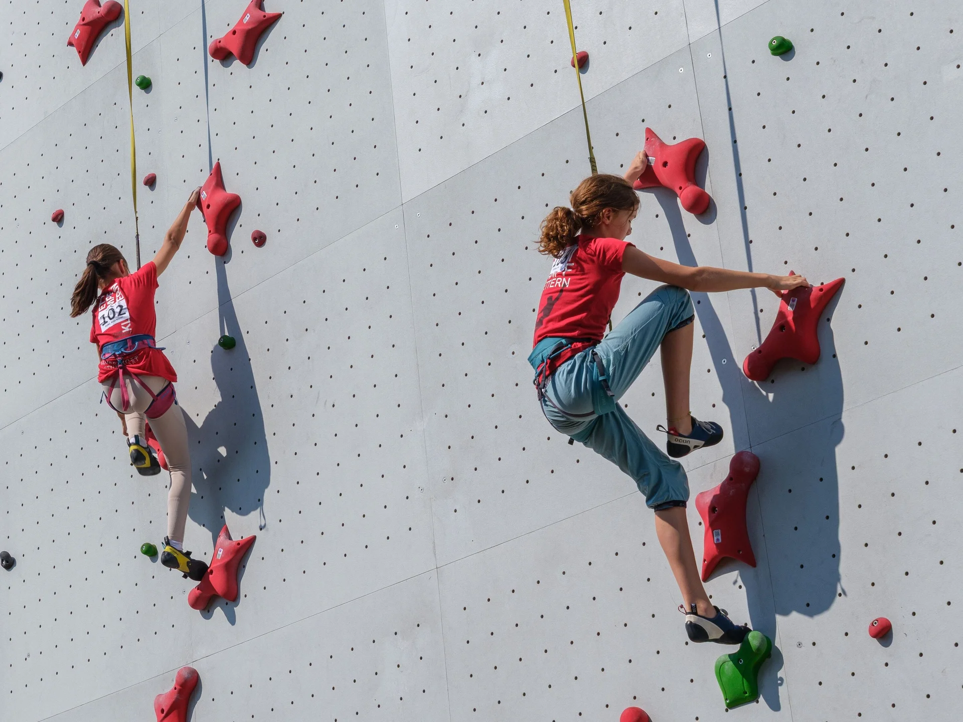 Zwei kletternde Mädchen an einer Kletterwand | © Oliver Gobin