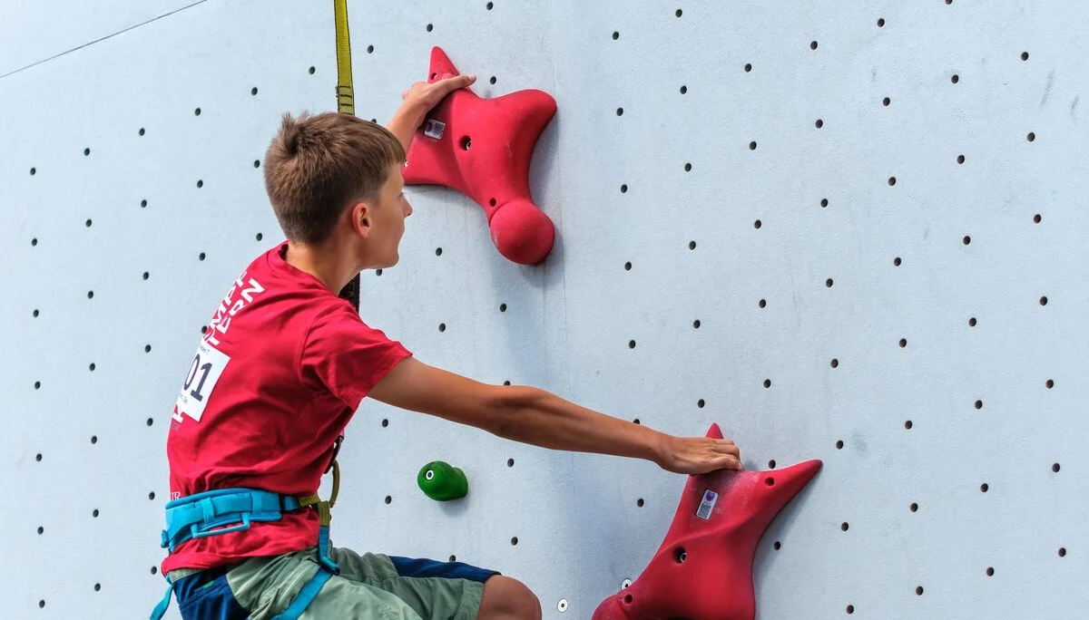 Kletternder Jugendlicher an einer Kletterwand | © Oliver Gobin