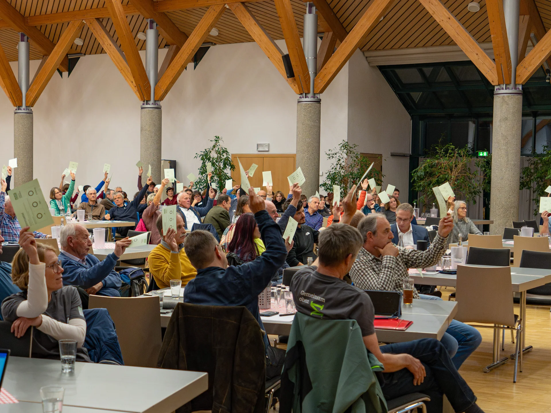 Sitzende Menschen halten Stimmzettel in die Höhe | © DAV Schwaben, Foto: Robin Wilkens