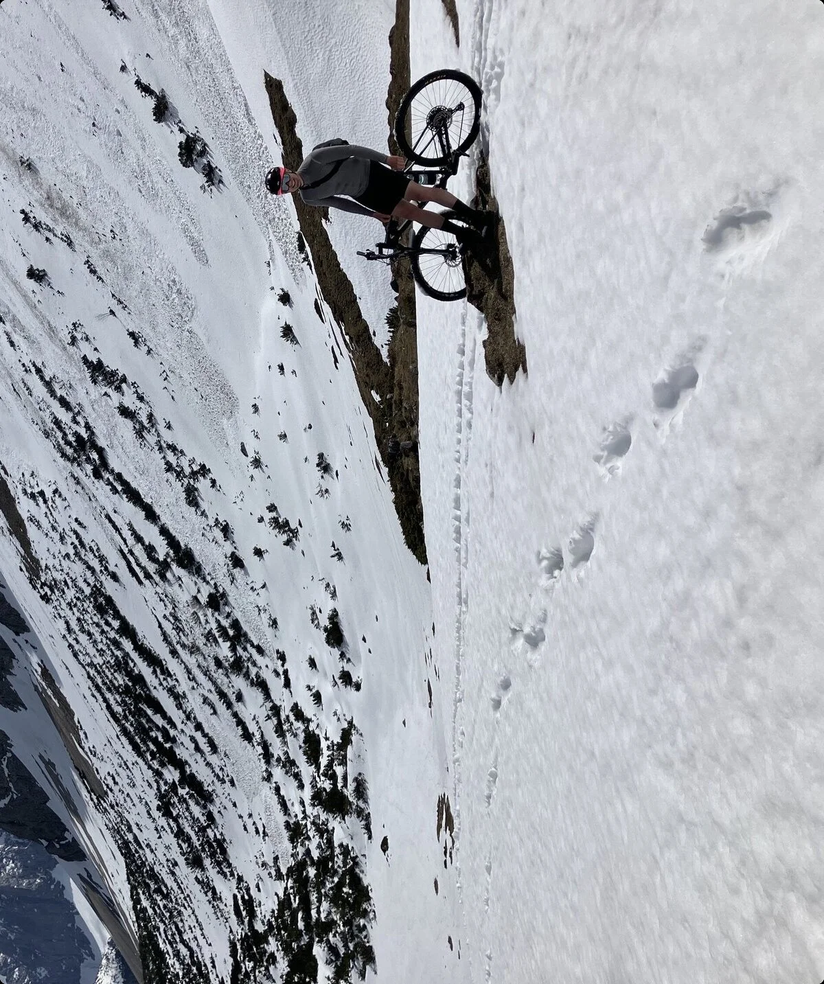 Mann mit Mountainbike im Schnee in den Bergen | © Fabian Brormann