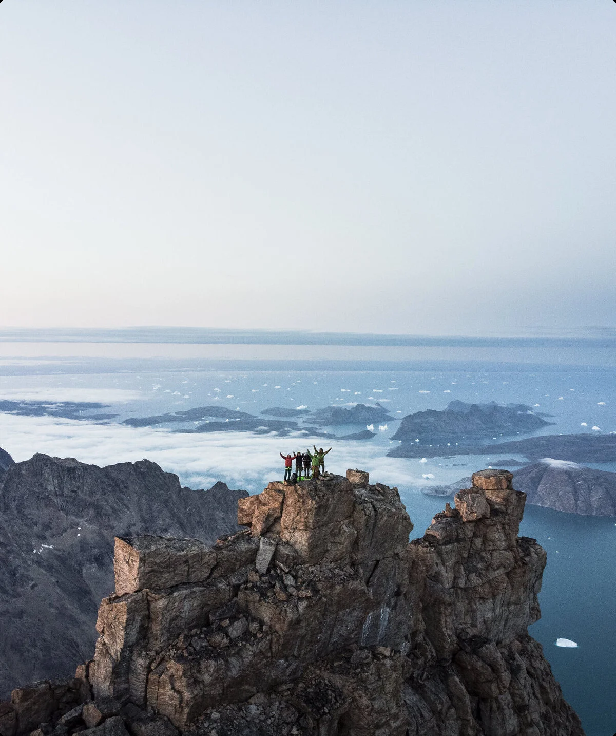 Gruppe von Kletterern steht auf Fels umgeben von einem Bergpanorama | © © Stefan Glowacz GmbH