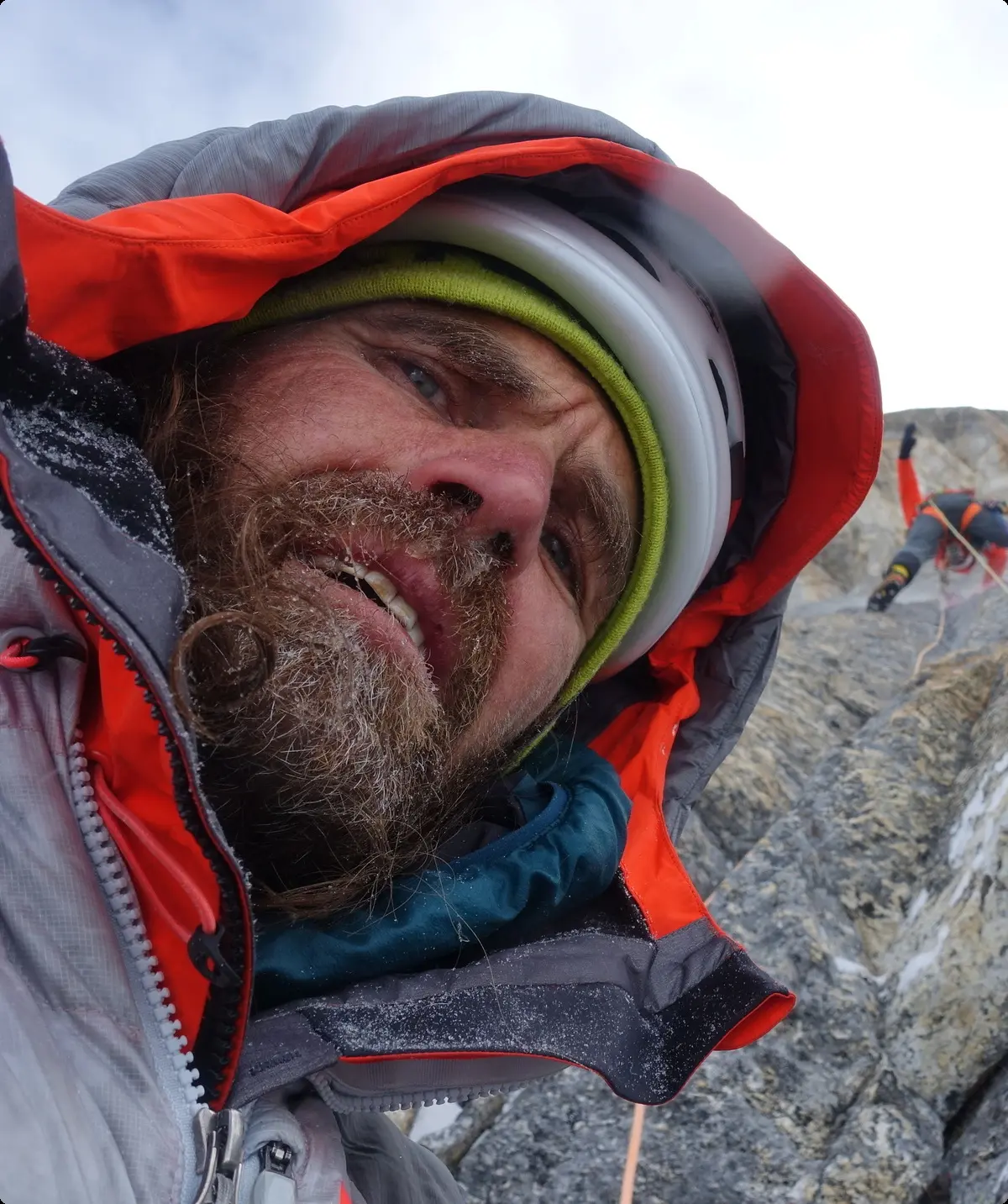 Selfie von einem Mann mit warmer Jacke vor Kletterwand | © Thomas Huber