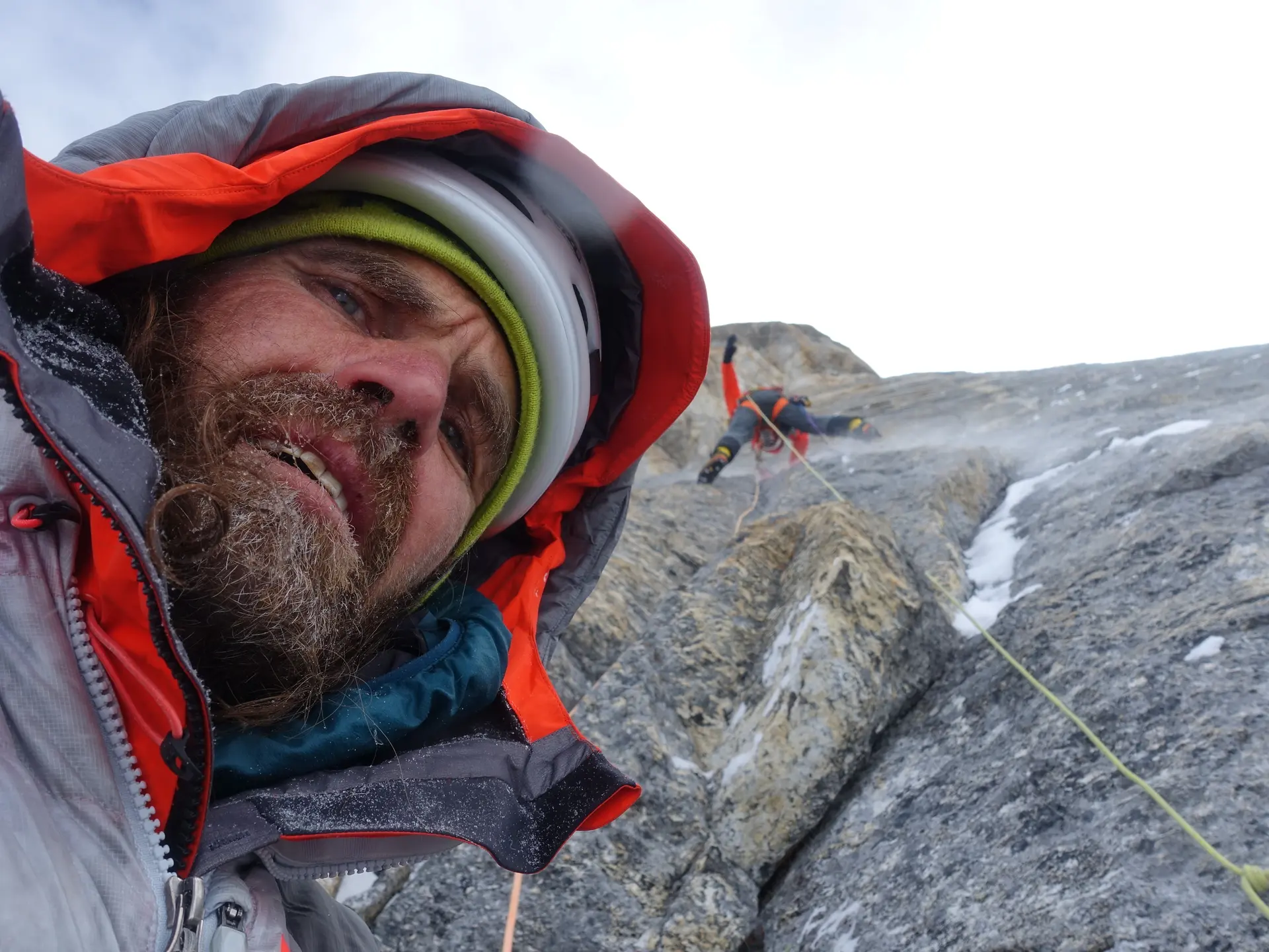 Selfie von einem Mann mit warmer Jacke vor Kletterwand | © Thomas Huber