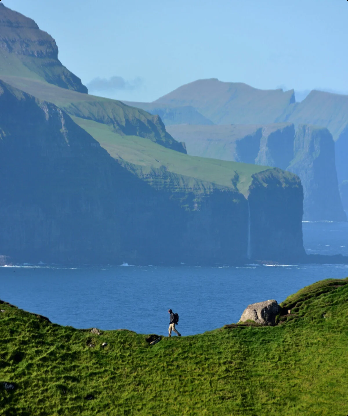 Person läuft am Horizont durch das Bild. Sie befindet sich auf einer Klippe. Im Hintergrund sind das Meer und Felsen zu sehen. | © Verena Schmidt