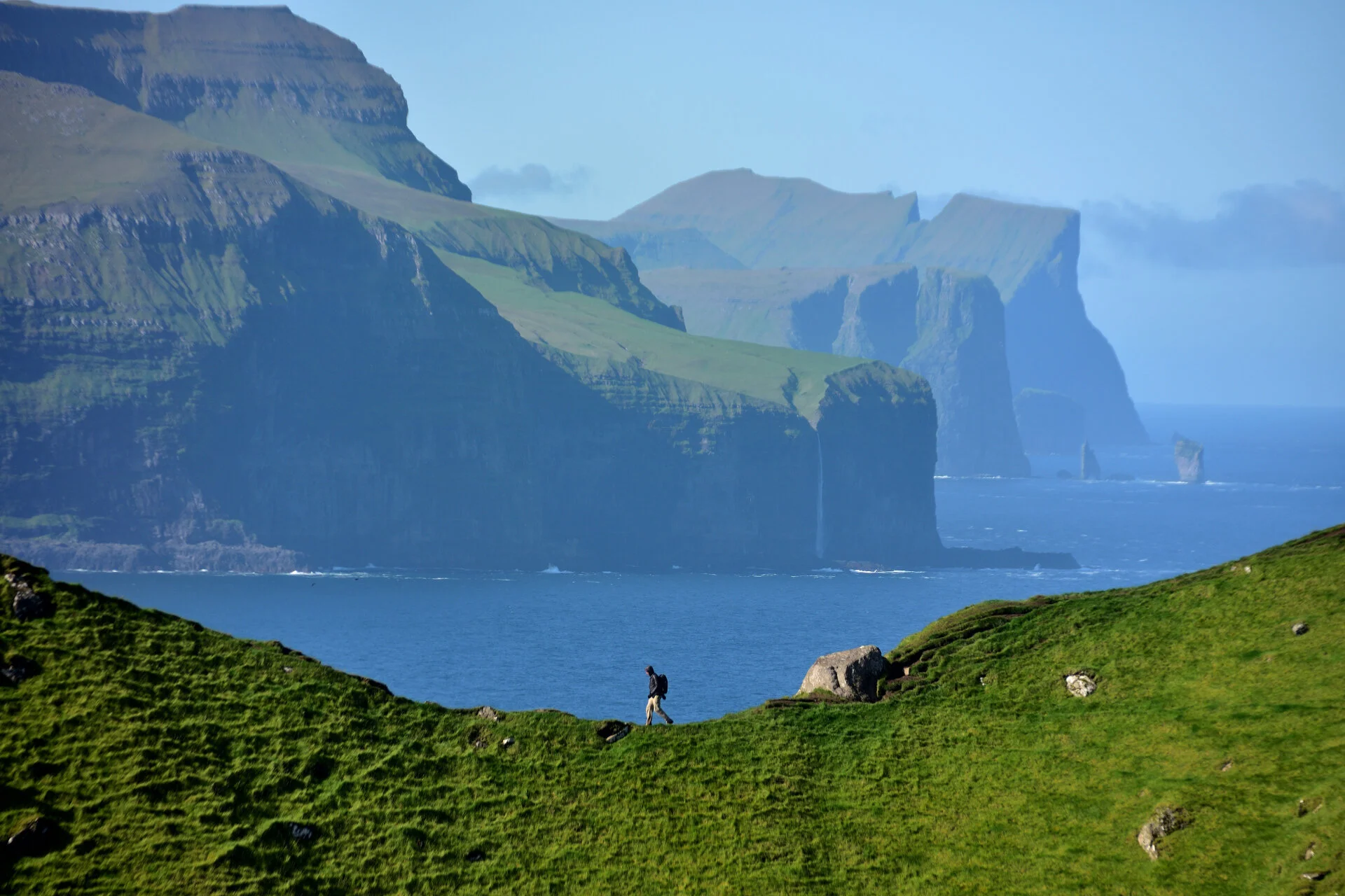 Person läuft am Horizont durch das Bild. Sie befindet sich auf einer Klippe. Im Hintergrund sind das Meer und Felsen zu sehen. | © Verena Schmidt