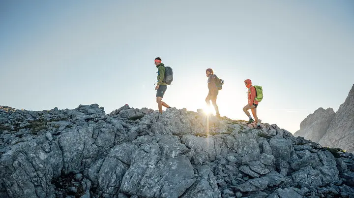 Drei Persinen besteigen im Sonnenaufgang einen Gipfel | © DAV / Julian Rohn